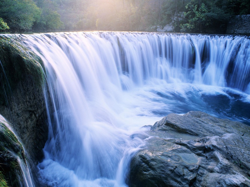 Columbia River Gorge waterfall wallpaper — long exposure photograph of wide waterfall with sunlight breaking through mist in Oregon